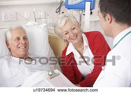 Doctor talking to senior couple on USA Hospital ward View Large Photo Image Picture - Doctor talking to senior couple on USA Hospital ward. Fotosearch