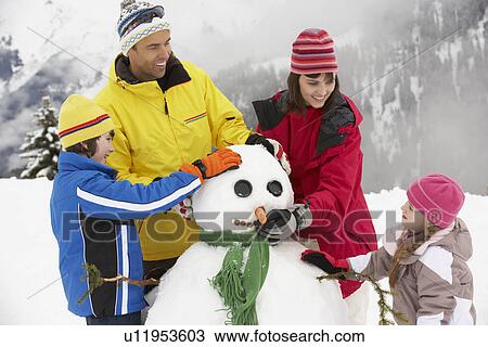 Family Building Snowman On Ski Holiday In Mountains View Large Photo Image Stock Image - Family Building Snowman On Ski Holiday In Mountains. Fotosearch