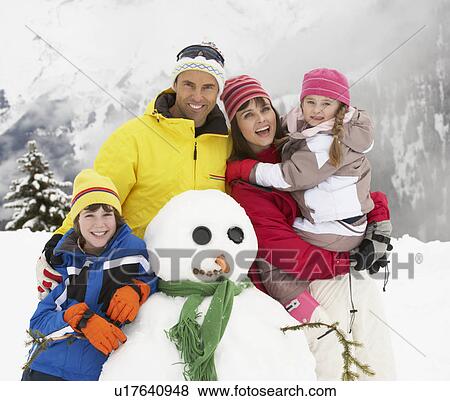 Family Building Snowman On Ski Holiday In Mountains View Large Photo Image Stock Photo - Family Building Snowman On Ski Holiday In Mountains. Fotosearch