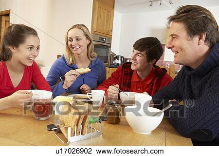 Stock Image - Family Eating Breakfast Together In Kitchen. Fotosearch