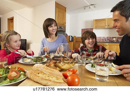Stock Photograph - Family Eating Lunch Together In Kitchen. Fotosearch