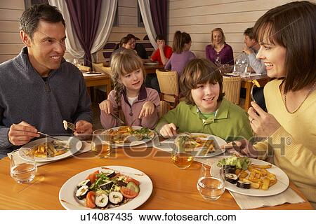 Stock Photography - Family Eating Lunch Together In Restaurant. Fotosearch