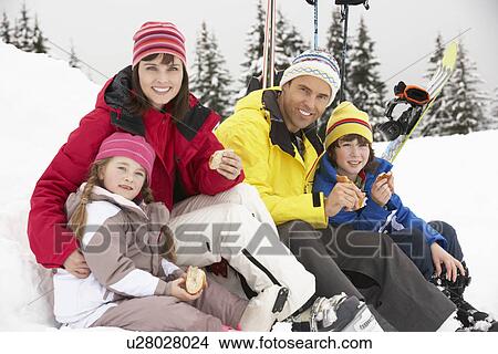 Picture - Family Eating Sandwich On Ski Holiday In Mountains. Fotosearch