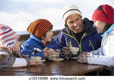 Stock Photograph - Family Enjoying Hot Drink In CafÃ© At Ski Resort. Fotosearch