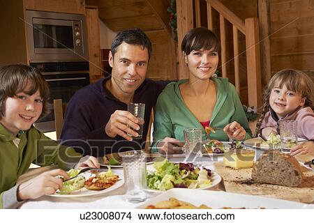Picture - Family Enjoying Meal In Alpine Chalet Together. Fotosearch