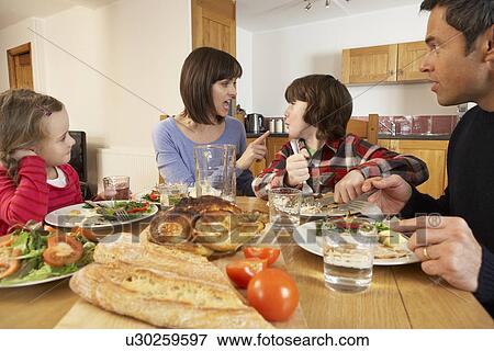 Stock Photo - Family Having Argument Whilst Eating Lunch Together In Kitchen. Fotosearch