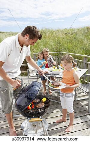 Picture - Family on vacation having barbecue. Fotosearch
