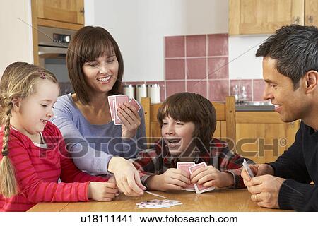 Stock Image - Family Playing Cards In Kitchen. Fotosearch
