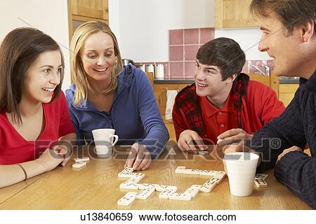 Stock Photo - Family Playing Dominoes In Kitchen. Fotosearch