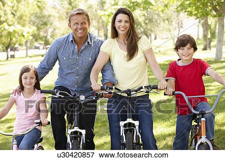Stock Photo - Family riding bikes in park. Fotosearch