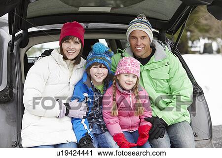 Stock Image - Family Sitting In Boot Of Car Wearing Winter Clothes. Fotosearch