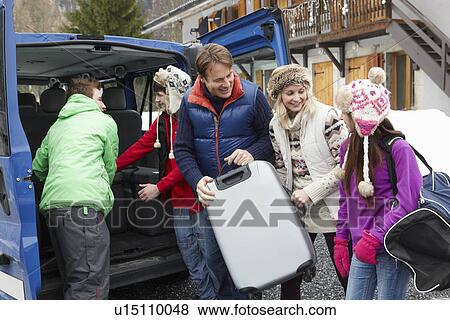 Family Unloading Luggage From Transfer Van Outside Chalet On Ski Holiday View Large Photo Image Stock Photo - Family Unloading Luggage From Transfer Van Outside Chalet On Ski Holiday. Fotosearch