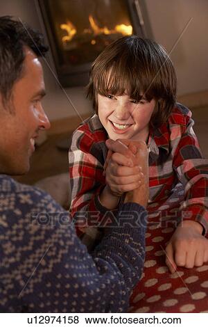 Father And Son Arm Wrestling By Cosy Log Fire View Large Photo Image Stock Photo - Father And Son Arm Wrestling By Cosy Log Fire. Fotosearch