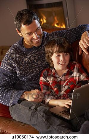 Father And Son Using Laptop Computer By Cosy Log Fire View Large Photo Image Picture - Father And Son Using Laptop Computer By Cosy Log Fire. Fotosearch
