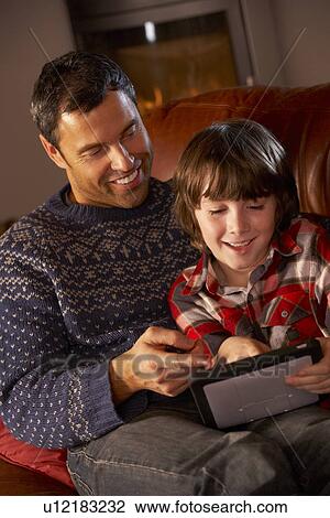 Father And Son Using Tablet Computer By Cosy Log Fire View Large Photo Image Stock Image - Father And Son Using Tablet Computer By Cosy Log Fire. Fotosearch