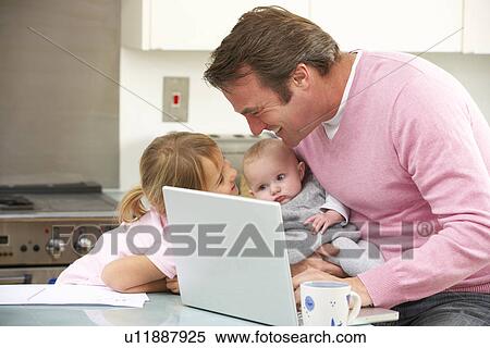 Father with children using laptop in kitchen View Large Photo Image Stock Photography - Father with children using laptop in kitchen. Fotosearch