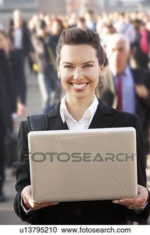 Female commuter in crowd using laptop View Large Photo Image Stock Image - Female commuter in crowd using laptop. Fotosearch
