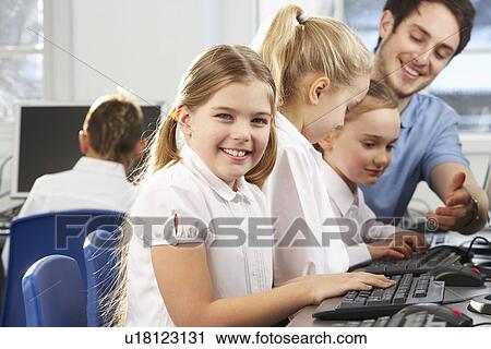 Stock Image - Girl in school class smiling to camera. Fotosearch