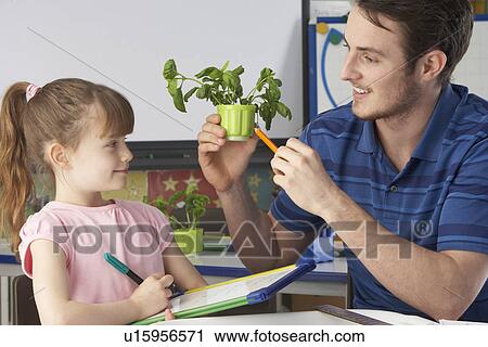 Stock Image - Girl learning about plants with teacher. Fotosearch