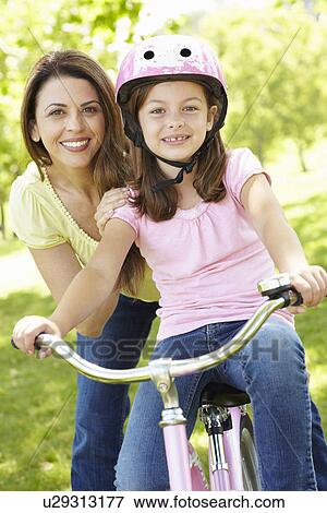 Girl on bike with mother View Large Photo Image Stock Photo - Girl on bike with mother. Fotosearch