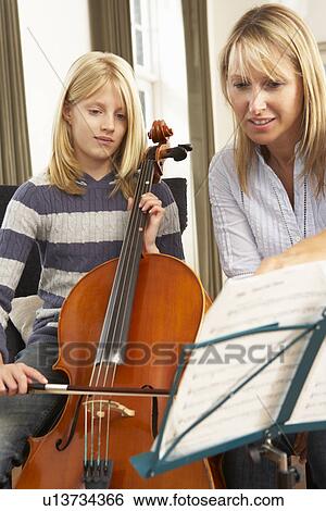 Girl playing cello in music lesson View Large Photo Image Stock Photograph - Girl playing cello in music lesson. Fotosearch