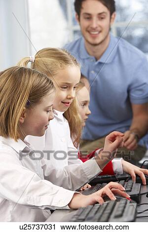 Girls using computers in class with teacher View Large Photo Image Stock Image - Girls using computers in class with teacher. Fotosearch