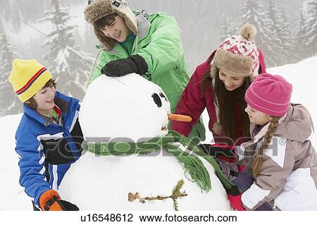 Group Of Children Building Snowman On Ski Holiday In Mountains View Large Photo Image Stock Image - Group Of Children Building Snowman On Ski Holiday In Mountains. Fotosearch