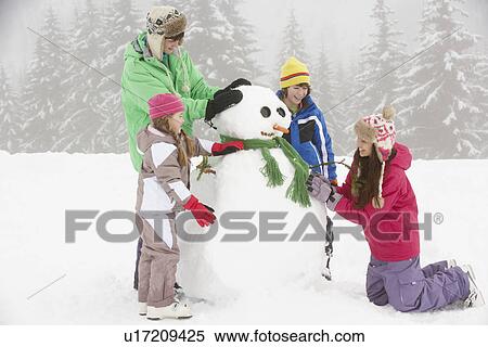 Group Of Children Building Snowman On Ski Holiday In Mountains View Large Photo Image Stock Photography - Group Of Children Building Snowman On Ski Holiday In Mountains. Fotosearch