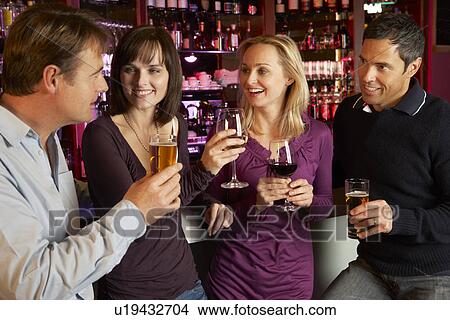 Picture - Group Of Friends Enjoying Drink Together In Bar. Fotosearch