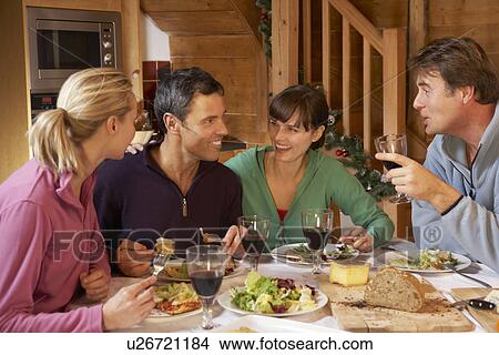 Picture - Group Of Friends Enjoying Meal In Alpine Chalet Together. Fotosearch
