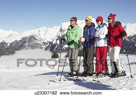 Stock Image - Group Of Middle Aged Couples On Ski Holiday In Mountains. Fotosearch