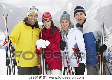 Stock Image - Group Of Middle Aged Couples On Ski Holiday In Mountains. Fotosearch