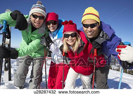 Stock Image - Group Of Middle Aged Couples On Ski Holiday In Mountains. Fotosearch