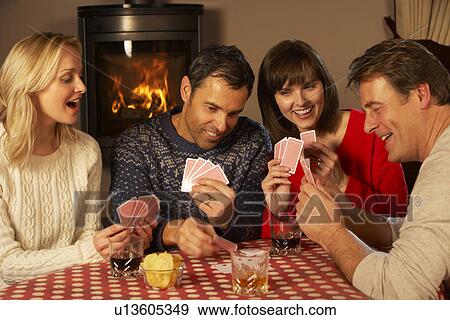 Stock Photo - Group Of Middle Aged Couples Playing Cards Together. Fotosearch