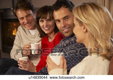 Group Of Middle Aged Couples Sitting On Sofa With Hot Drinks Talking View Large Photo Image Picture - Group Of Middle Aged Couples Sitting On Sofa With Hot Drinks Talking. Fotosearch