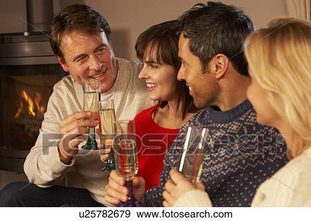 Stock Photo - Group Of Middle Aged Couples Sitting On Sofa With Champagne. Fotosearch