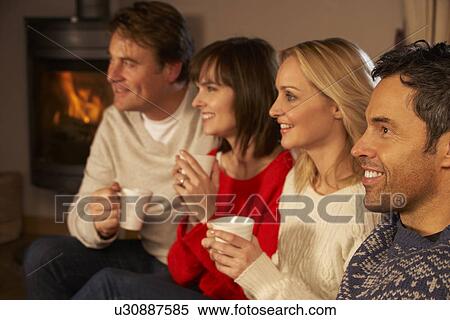 Group Of Middle Aged Couples Sitting On Sofa With Hot Drinks Watching TV View Large Photo Image Stock Photography - Group Of Middle Aged Couples Sitting On Sofa With Hot Drinks Watching TV. Fotosearch