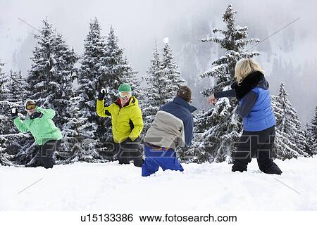 Stock Photograph - Group Of Young Friends Having Snowball Fight On Ski Holiday In Mountains. Fotosearch