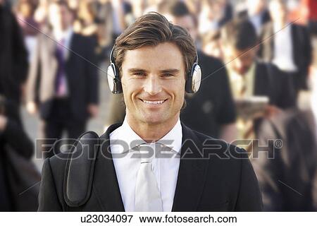 Stock Photo - Male commuter in crowd wearing headphones. Fotosearch