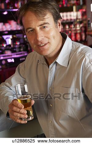 Stock Photography - Man Enjoying Drink At Bar. Fotosearch