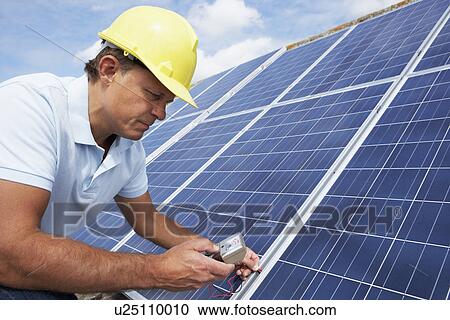 Stock Image - Man installing solar panels. Fotosearch