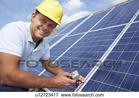 Stock Photo - Man installing solar panels. Fotosearch