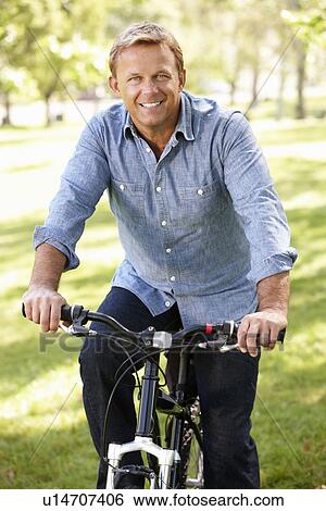 Man riding bike in park View Large Photo Image Stock Photograph - Man riding bike in park. Fotosearch