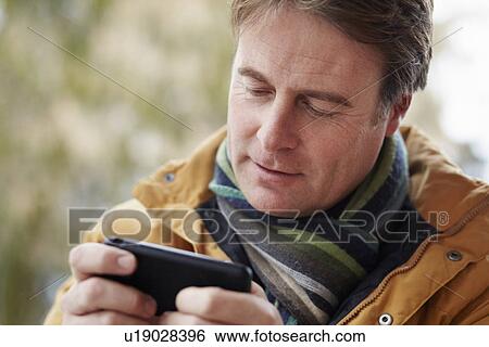 Man Texting On Smartphone Wearing Winter Clothes View Large Photo Image Stock Photograph - Man Texting On Smartphone Wearing Winter Clothes. Fotosearch