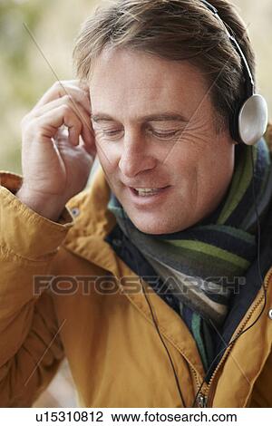 Man Wearing Headphones And Listening To Music Wearing Winter Clothes View Large Photo Image Stock Image - Man Wearing Headphones And Listening To Music Wearing Winter Clothes. Fotosearch