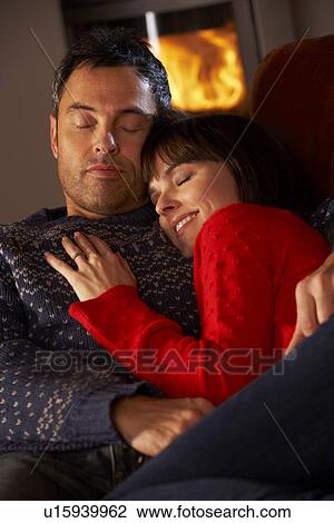 Middle Aged Couple Cuddling On Sofa By Cosy Log Fire View Large Photo Image Stock Image - Middle Aged Couple Cuddling On Sofa By Cosy Log Fire. Fotosearch