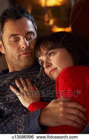 Middle Aged Couple Cuddling On Sofa By Cosy Log Fire View Large Photo Image Stock Photograph - Middle Aged Couple Cuddling On Sofa By Cosy Log Fire. Fotosearch