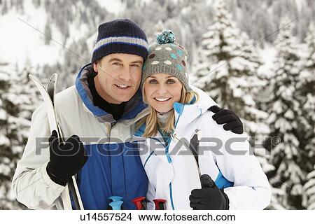 Picture - Middle Aged Couple On Ski Holiday In Mountains. Fotosearch