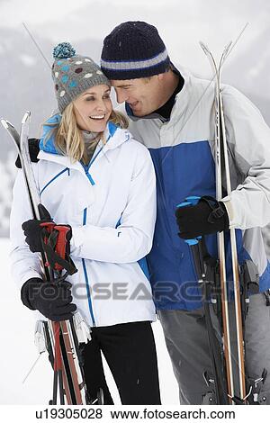 Stock Photo - Middle Aged Couple On Ski Holiday In Mountains. Fotosearch