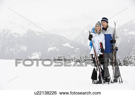 Stock Photograph - Middle Aged Couple On Ski Holiday In Mountains. Fotosearch